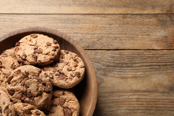Delicious chocolate chip cookies on wooden table, top view. Space for text