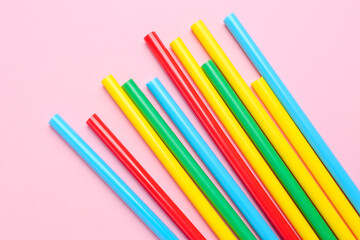 Many colorful glue sticks on pink background, flat lay