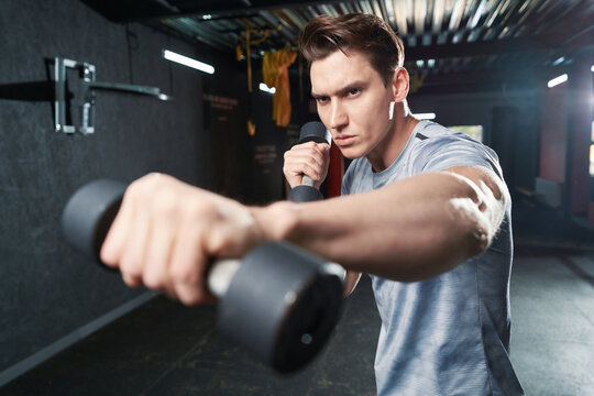 Focused determined boxer shadow-boxing with hand weights
