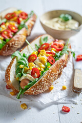 Tasty hot dogs with arugula, chilli pepper and corn.