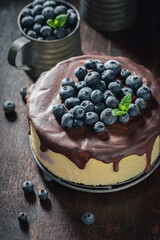 Homemade and sweet cheesecake with blueberries and chocolate glaze.