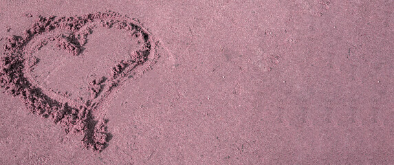 A heart drawn in the sand. Beach background. Top view, space for text, pink tinting