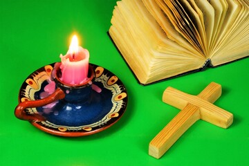 Latin cross, a Christian religious attribute. An open bible and a burning candle gives light.