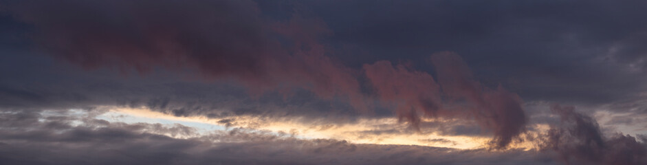 Fototapeta na wymiar Leaden, storm clouds covered the sunset. Cumuliform cloudscape on blue sky. Tragic gloomy sky.