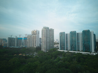 view of high rise public housing on cloudy day, with lush green public park in foreground, in singapore