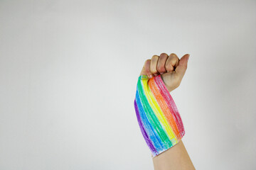 
raised hand with the colors of the gay flag as a symbol of the fight for freedom of expression on a white background