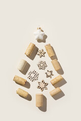 Wine corks as Christmas Tree on beige background, sun shadows. Wooden bottle stoppers as xmas, New Year decoration. Minimal Christmas flatlay, Happy New Year card, pastel neutral, design menu