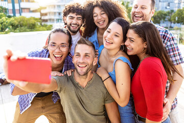 Fototapeta premium Happy young group of multiracial friends having fun on summer holidays - Millennial friends taking selfie together while laughing outdoors