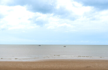 Fototapeta na wymiar The sand beach,sea,fishing boats and soft sky background.