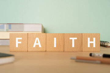 信頼・信念のイメージ｜「FAITH」と書かれたブロックが置かれたデスク