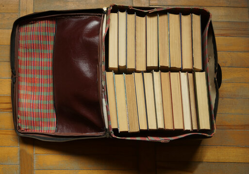 suitcase stuffed with books. top view image. Stack of hardback books in an old suitcase. Back to school idea. empty Copy space.