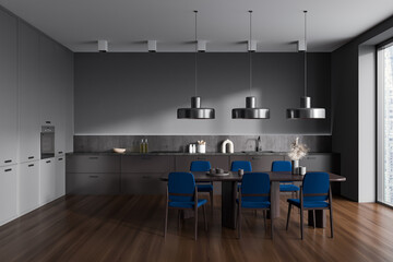 Grey kitchen interior with eating table and seats, appliances and window