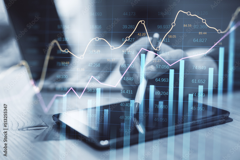 Poster businessman hand using tablet and laptop at desktop with abstract glowing business chart with index and growth on blurry background. Finance, trade and market report concept. Double exposure.