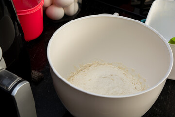 flour inside a mixer in a black marble surface. preparing family snack