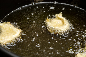 frying some dough on hot soy oil