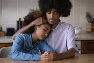 Teenage African guy calming girl, hugging her, express sympathy, gives mental support, encouraging,...