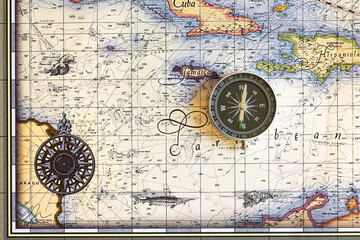 Fototapeta na wymiar Compass lies on an old map of the Caribbean Sea