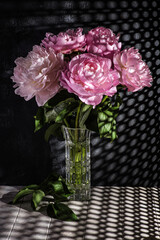 peonies in a vase on a dark background
