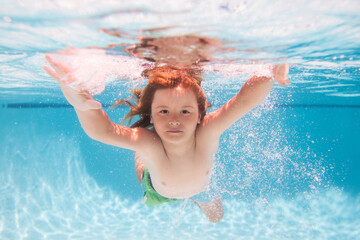 Child swim under water in sea. Kid swimming in pool underwater. Happy boy swims in sea underwater....