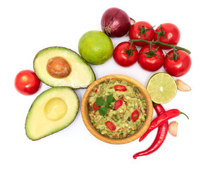 Wooden bowl of guacamole dip sauce and ingredients isolated on white background