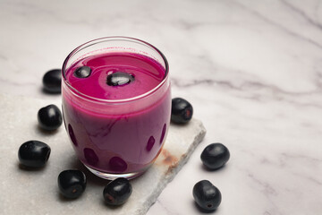 Close-Up of Shake or pulp or juice of Indian Ayurvedic medicinal fresh organic fruit jamun (Syzygium Cumini) with its seeds plum