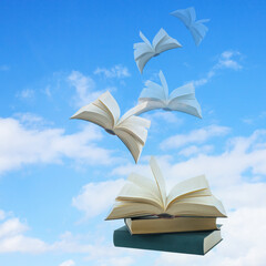 Open books flying into sky with clouds.