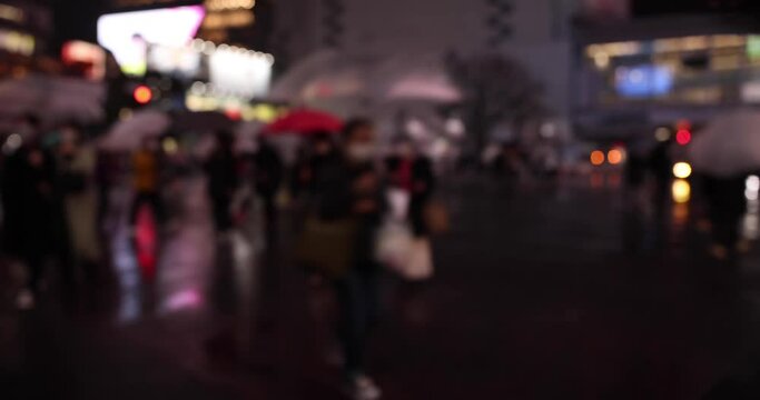A high speed shooting of defocused walking people at Shibuya crossing rainy day
