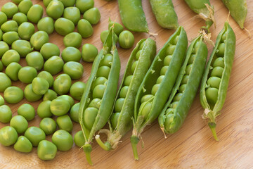 Closeup shot of fresh green peas on wooden background