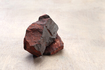Iron ore stone on a textured wooden base.
