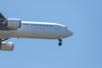 青空を背景に羽田空港に着陸態勢に入る旅客機