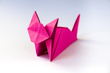 Pink paper cat origami isolated on a white background