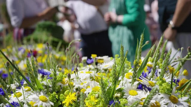 Traditional summer fair of flowers and bouquets for the Ligo holiday in Riga. Herbal and fruit fairs in the center of the Latvian capital. Summer sunny day and a lot of cheerful tourists and locals. S