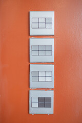 Four switch pattern on orange wall