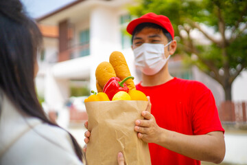 The shipper wears a mask, delivery food to the home of the online buyer. The sender has a service...