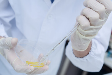 A chemist researcher collects a liquid to experiment and study. High quality photo