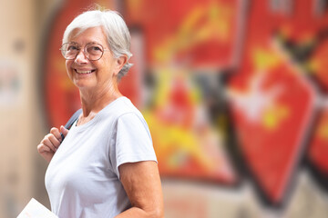 Attractive smiling senior woman on vacation in Seville, Spain, walking around the old city looking at camera © luciano