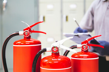 Fire extinguisher has hand engineer inspection checking pressure gauges to prepare fire equipment for protection and prevent in emergency case and safety or rescue and alarm system training concept. - obrazy, fototapety, plakaty