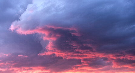Fototapeta na wymiar Swirling evening clouds illuminated by the setting sun