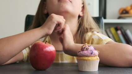 the girl chooses between a cupcake and an apple - Powered by Adobe