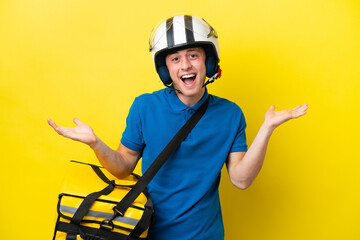 Young Brazilian man with thermal backpack isolated on yellow background with surprise facial expression