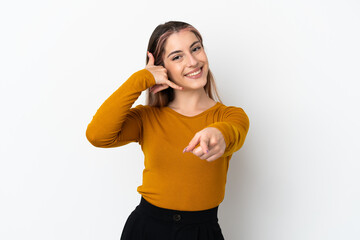 Young caucasian woman isolated on white background making phone gesture and pointing front