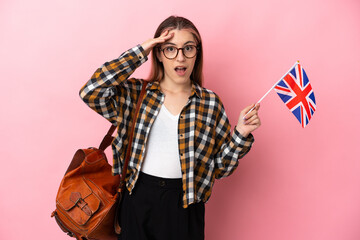 Fototapeta Young hispanic woman holding an United Kingdom flag isolated on pink background with surprise expression obraz