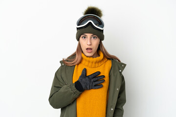 Skier caucasian woman with snowboarding glasses isolated on white background surprised and shocked while looking right