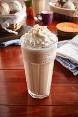 A glass of healthy fresh TOFFEENUT FRAPPE isolated on wooden background side view