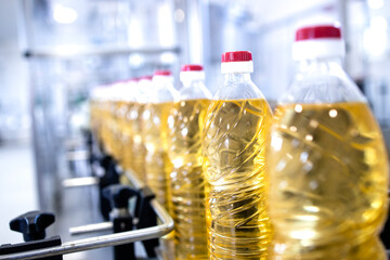 Vegetable oil production and bottles filled with sunflower oil being transported on conveyor...