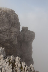 Mountain massif through dense fog, Dolomites, Italian Alps.