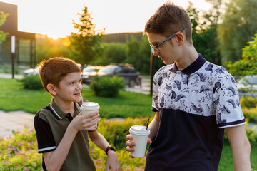 Obraz premium Close-up of two child holding disposable cups of coffee.