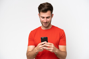 Young caucasian man isolated on white background sending a message or email with the mobile