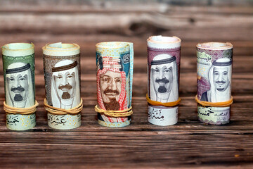 Saudi Arabia money roll riyals banknotes isolated on wooden background, Saudi riyals cash money...