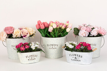 Maceteros con ramos de flores de rosas, tulipanes y prímulas.